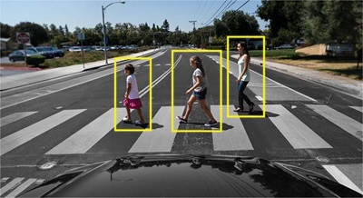 Pedestrians on a cross walk highlighted with yellow boxes